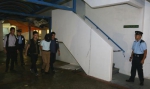 张祺忠身着白色上身、卡其色西裤，被警方用黑布蒙头押往住所搜查/图自港媒 - 西安网