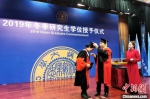 图为拨穗正冠并颁授学位证书。　梅镱泷 摄 - 陕西新闻