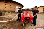 图为漳州南靖县土楼专职消防队员为消防摩托加水。　王东明 摄 - 西安网