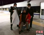 1月30日，在建瓯西火车站站台上，姐姐王雯萱(右)帮扶重点旅客下车。　李一明 摄 - 西安网